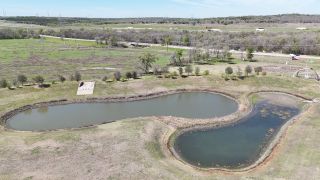 A serene landscape with picturesque ponds in Whisper Valley by AHA Dream Homes, LLC in Manor, TX.