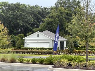 A charming grey home with lush landscaping in Wynwood by D.R. Horton (Ocoee, FL).