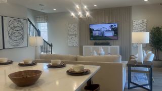 A modern living area with chic decor, a cozy couch, stylish lighting, and abstract artwork, perfect for relaxing and entertaining.