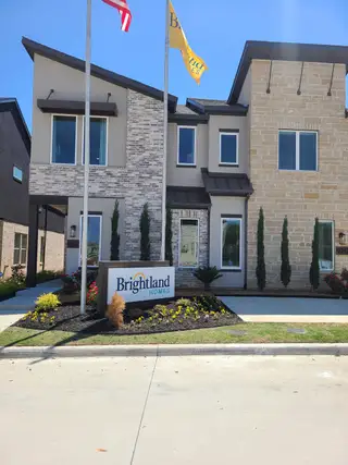 Street view A modern home with mixed brick and stone facade in Collin Creek by Brightland Homes (Plano, TX).