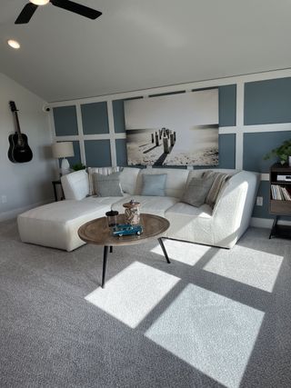 Model Home A cozy living area featuring a plush sectional, modern artwork, and soft lighting accents.