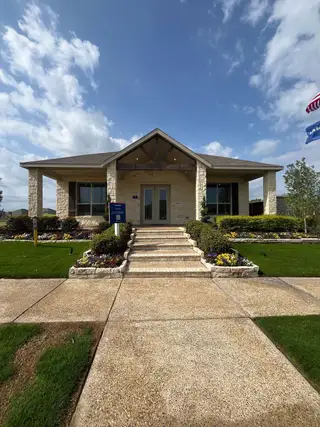 Street view Charming stone-front home with manicured lawn in Eastland: Watermill Collection by Lennar (Crandall, TX).
