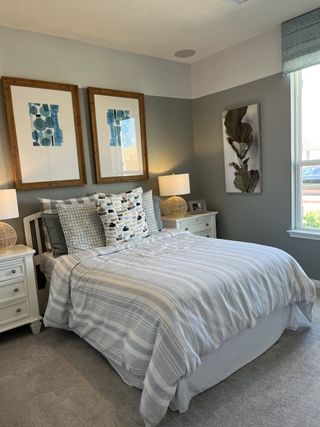 A cozy bedroom with layered bedding, twin nightstands, and framed art for a modern touch.