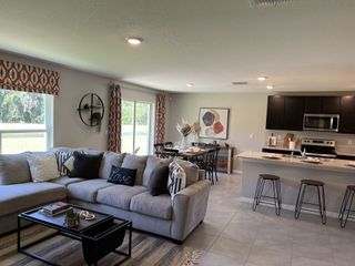 An inviting open-concept living area with warm accents and scenic backyard views.