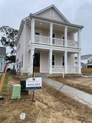 Street view A charming two-story home with a welcoming porch in Oak Bluff by Dream Finders Homes (Charleston, SC).