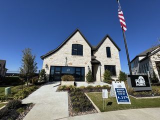 Beautiful stone home with manicured lawn in Legacy at Lake Dunlap by Pulte Homes (New Braunfels, TX).