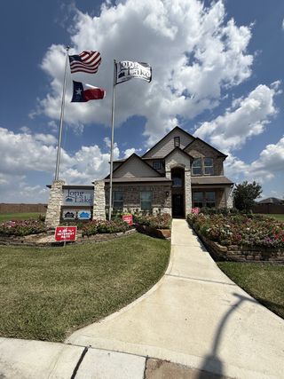 Street view A beautiful stone and brick home with lush landscaping in Canterra Creek by CastleRock Communities (Rosharon, TX).