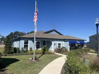 Street view A charming blue home with a manicured lawn in Marion Ranch by Pulte Homes (Ocala, FL).