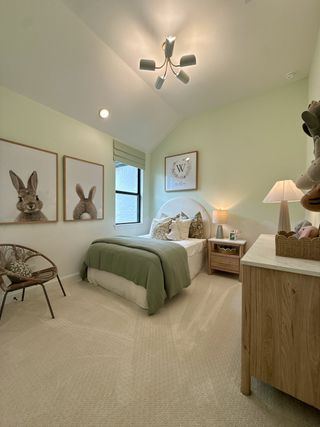 A cozy bedroom with soft lighting, playful bunny art, and warm, neutral decor.
