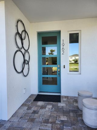 A modern entrance with a blue door and sleek decor in Trinity Place by DRB Homes, St. Cloud, FL.
