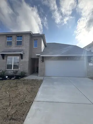 A stylish two-story brick home with a two-car garage and landscaped front yard in Vista Ridge by HistoryMaker Homes (Live Oak, TX).