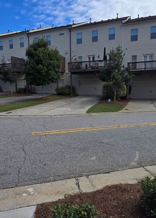 Street view Townhomes with spacious balconies and green landscaping in West Village by Peachtree Residential (Smyrna, GA).