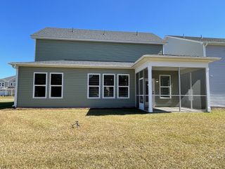 A charming home with green siding and screened porch in The Groves of Berkeley by Beazer Homes (Moncks Corner, SC).