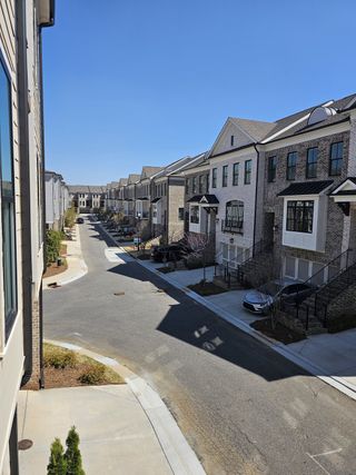 A row of elegant townhomes with brick facades in Towns on Thompson by The Providence Group (Alpharetta, GA).