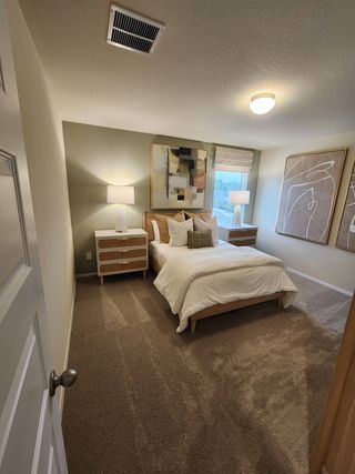 A cozy bedroom with modern art, plush carpeting, and soft lighting creating a warm, inviting atmosphere.