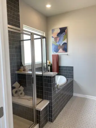 A modern bathroom featuring a sleek glass shower, mosaic tiles, and abstract art for a stylish touch.