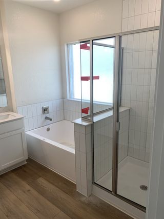 Model Home A sleek bathroom with a glass-enclosed shower, soaking tub, and white subway tiles.