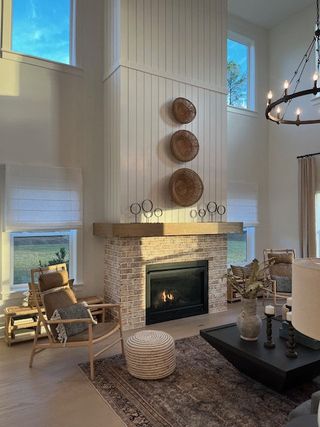 A cozy living room with a brick fireplace, wicker accents, and elegant high ceilings.