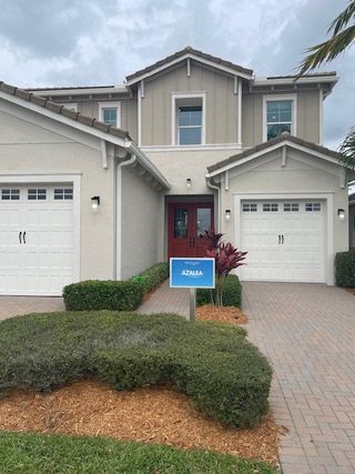 A charming two-story home with twin garages and manicured landscaping in Westlake by Minto Communities (Westlake, FL).