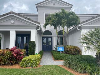 A modern home with elegant arches and lush landscaping in Westlake by Minto Communities (Westlake, FL).