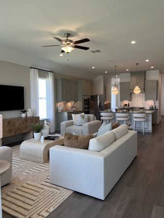 A modern living area with elegant gray cabinetry, cozy seating, and a bright and airy open-concept design.