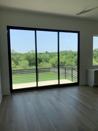 Expansive room with light wood floors and large sliding doors opening to a scenic view.