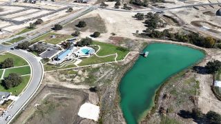 A scenic view of green landscapes and water features in Capitol Collection at Lariat by Tri Pointe Homes (Liberty Hill, TX).