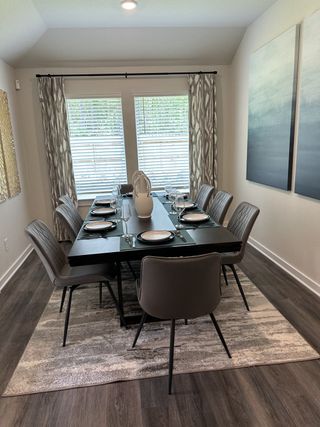 A modern dining room with elegant table settings, neutral decor, and abundant natural light through large windows.