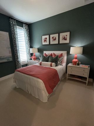 A cozy bedroom with coral accents, dark green walls, and modern furnishings.