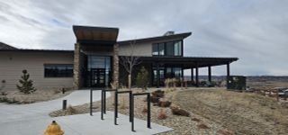 A sleek modern building with stone and wood accents in Montaine by Brightland Homes (Castle Rock, CO).