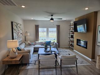 A cozy living room with a sectional sofa, modern fireplace, and stylish decor. Large windows allow natural light to flow in.