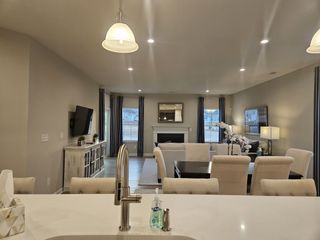 A spacious open living area with elegant furnishings, a wall-mounted TV, and soft lighting for a cozy ambiance.