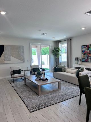 A modern living room featuring chic decor, neutral tones, and ample natural light, perfect for relaxation and entertaining.