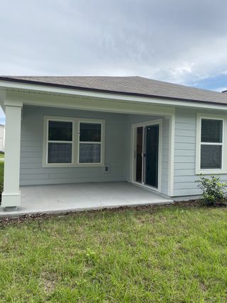 A charming patio with sliding doors and a grassy yard in Wells Landing by Centex (Jacksonville, FL).