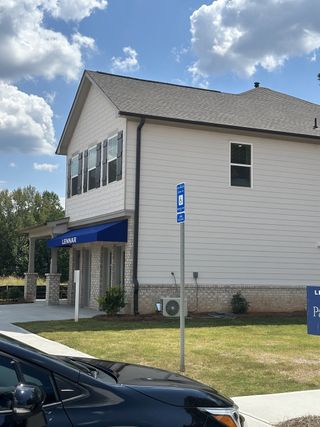Street view A modern white building with blue accents and brickwork in Millers Pointe by Lennar (Conyers, GA).