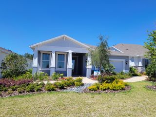 A charming craftsman-style home with a welcoming front porch and lush landscaping in Del Webb Minneola by Del Webb (Minneola, FL).