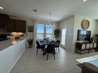 A bright dining area with elegant furnishings, modern decor, and natural light streaming in from large windows.