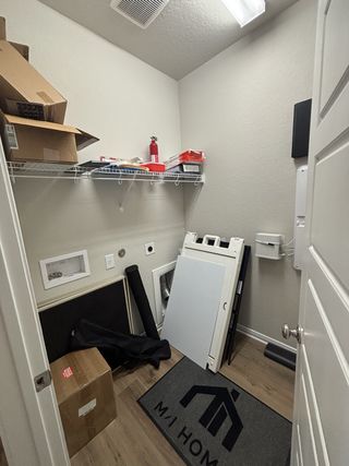 A walk-in closet with sleek wood flooring and ample hanging space in Blue Ridge Ranch by M/I Homes (San Antonio, TX).