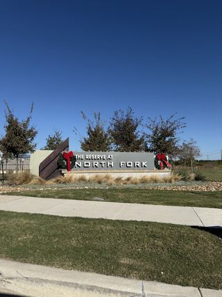 A welcoming entrance sign adorned with festive decorations at the Reserve at North Fork by Pulte Homes (Leander, TX).