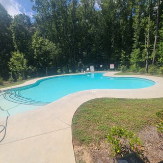 A serene pool surrounded by lush woods in Paces Estates by McKinley Homes (Lithia Springs, GA).