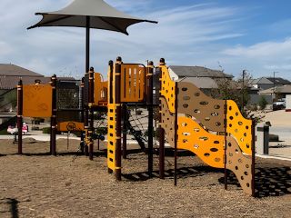 A lively playground with bright equipment and shade in Sunrise – Canyon Series by Landsea Homes (Surprise, AZ).