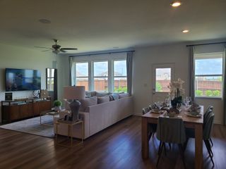 Spacious living-dining area with modern furnishings, large windows, and hardwood floors. Perfect for entertaining and relaxing.