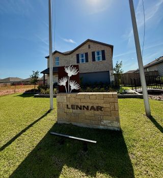 A beautiful brick home with dark shutters and landscaped lawn in The Grand Prairie: Watermill Collection by Lennar (Hockley, TX).