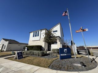Contemporary stone-accented home with neat landscaping in Cielo East by Masonwood Homes, Round Rock, TX.