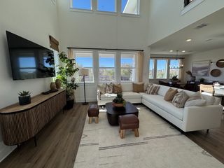 A bright, open living space with a large sectional, wood floors, and modern decor, offering a cozy and inviting atmosphere.