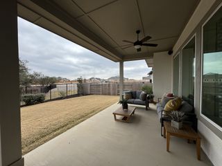A cozy patio with comfortable seating, stylish decor, and a view of the fenced backyard, perfect for relaxation and entertaining.