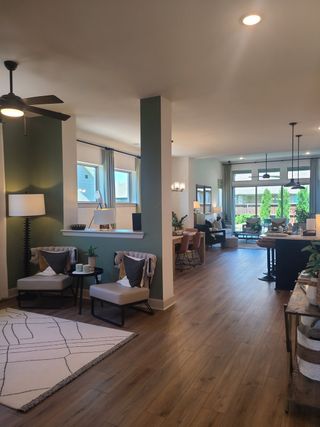 Model Home An open-concept living area with hardwood floors, modern decor, and abundant natural light.