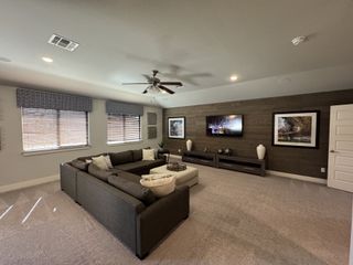 A spacious living room with a cozy gray sectional, wood accent wall, and modern decor, offering a perfect gathering space.