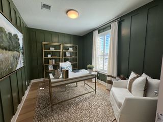 A sophisticated home office with deep green paneling, gold shelving, and elegant decor, perfect for productivity and style.
