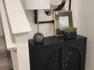 A cozy landing area with a chic black console, abstract artwork, and modern décor, adding a touch of sophistication.